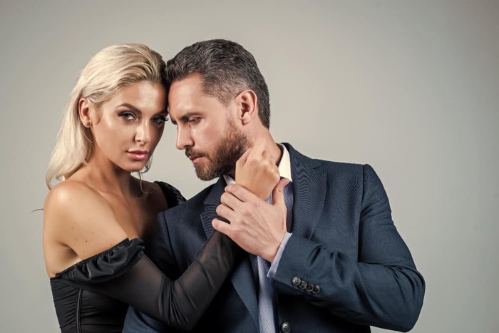 Well-dressed business couple embracing at formal event