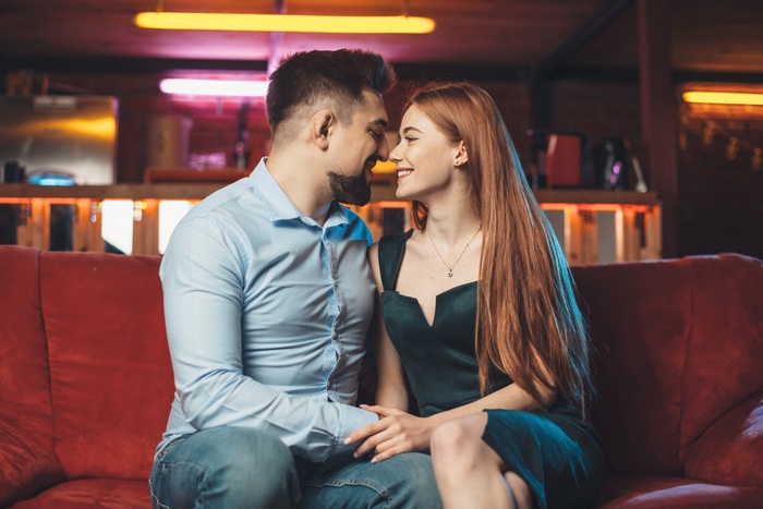 Couple smiling on red couch